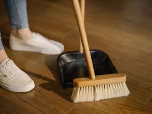 dust pan and brush sweeping wooden floor